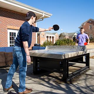两个学生在外面打乒乓球. 